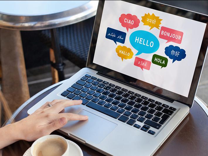 Different languages in speech bubbles on a laptop