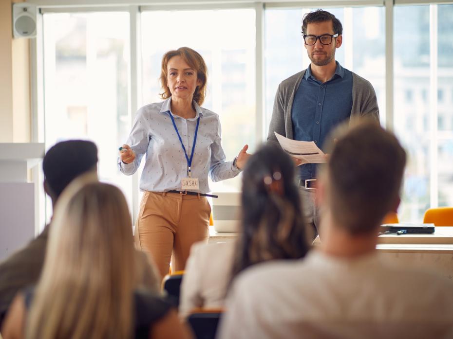 Two teachers at the front of a class full of students