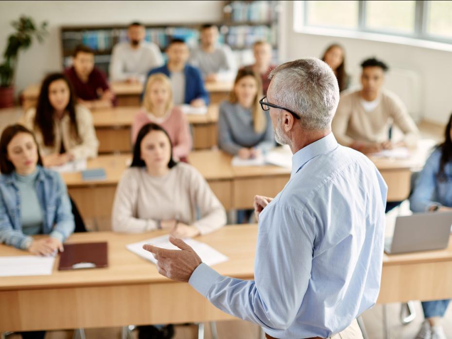 A teacher at the front of a class full of students