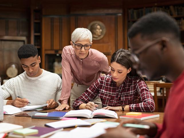 A lecturer observes her students reading