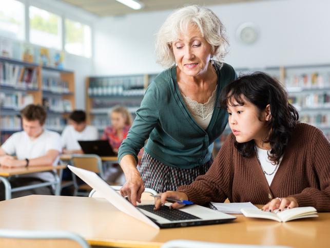 An educator helps a student in class