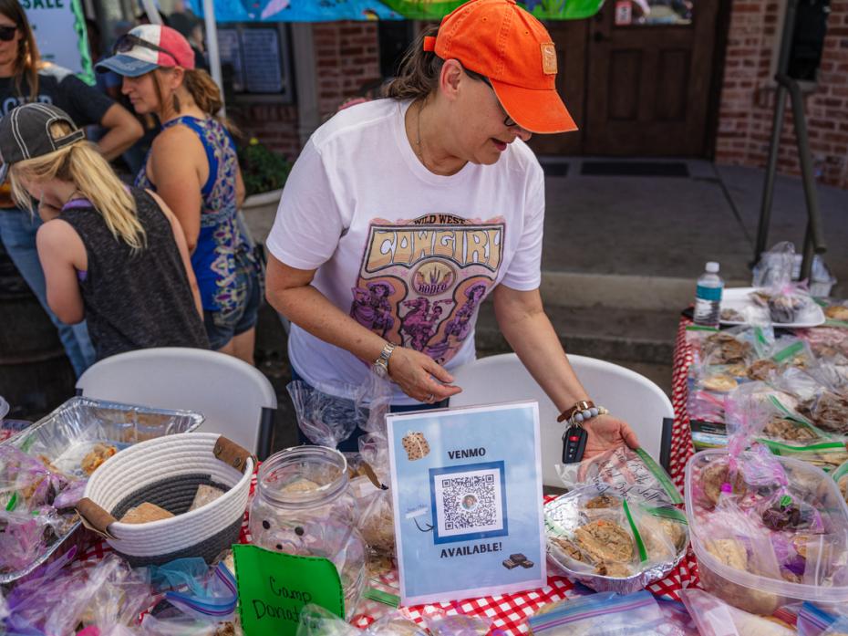 A person selling baked goods at a fundraising event