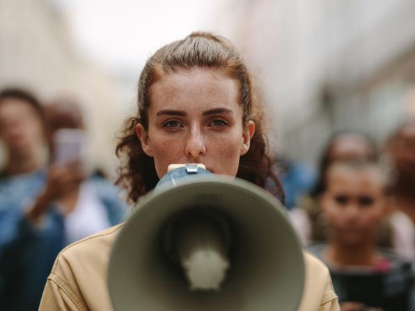 A woman holds a megaphone at a protest