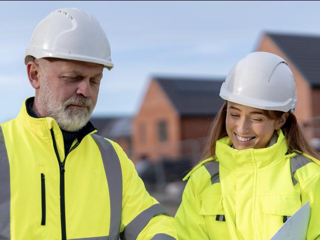 Workers in hard hats and hi-vis discuss their plans