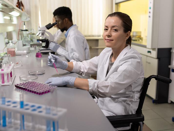 Female scientific researcher in wheelchair in lab