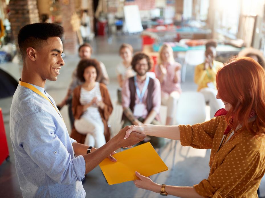 A teacher accepting an award in front of colleagues