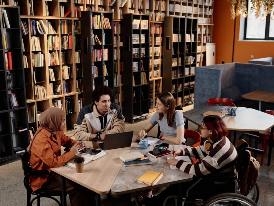 A library with a group of students having a discussion at a table