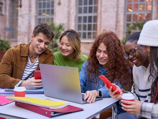 Students work together over a laptop
