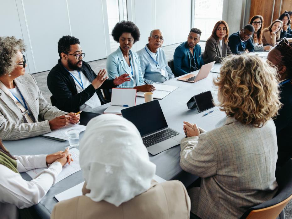 Employees sitting at a long table in a boardroom