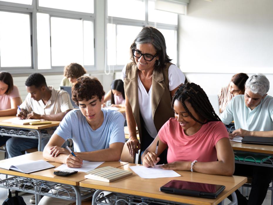 A teacher helping students with their work in class