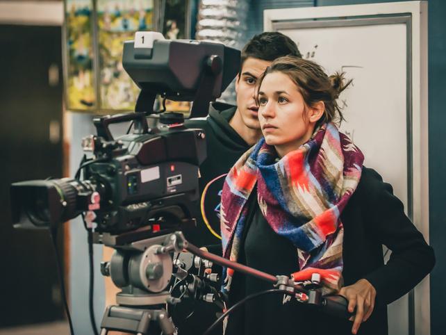 A young woman operates a camera
