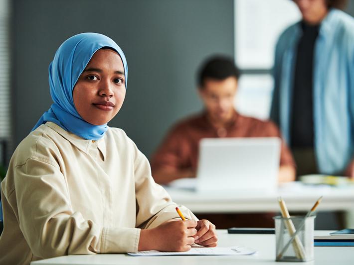 Young Muslim female student in university classroom