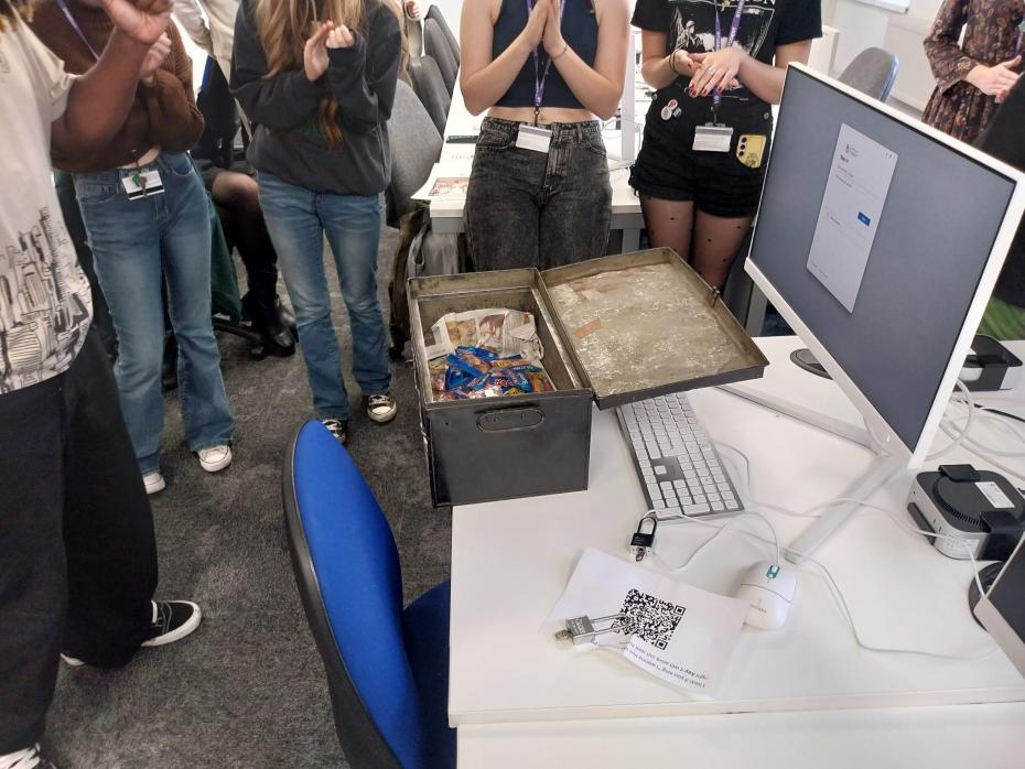 A group of students celebrating around an unlocked chest full of sweets