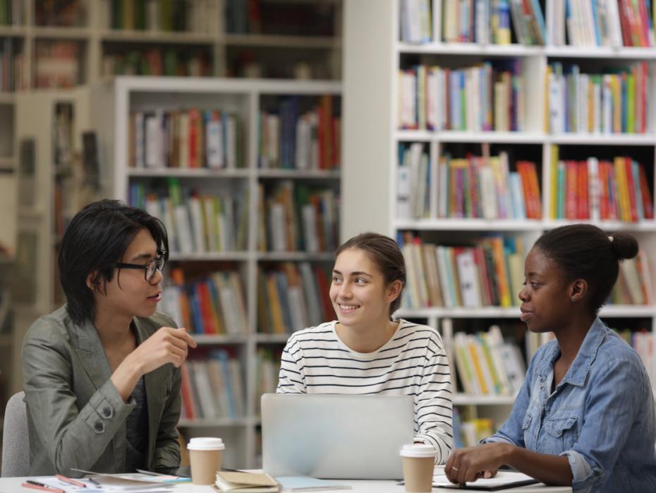 Three students working together in a library
