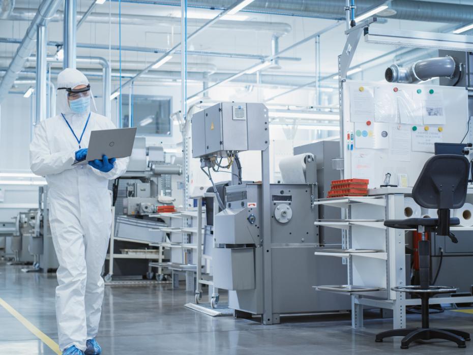 A technician holding a laptop in a lab