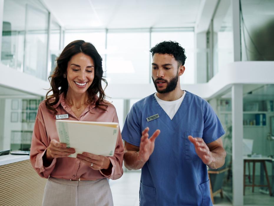 Two healthcare professionals consulting a document