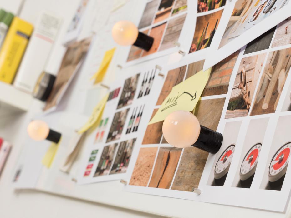 Whiteboard with photographs and sticky notes on a magnetic wall