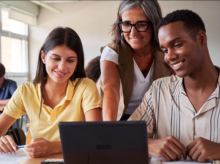 University teacher helping two multiracial students