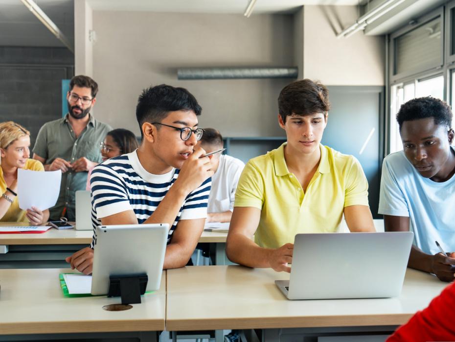 A group of students at a table looking at their screens