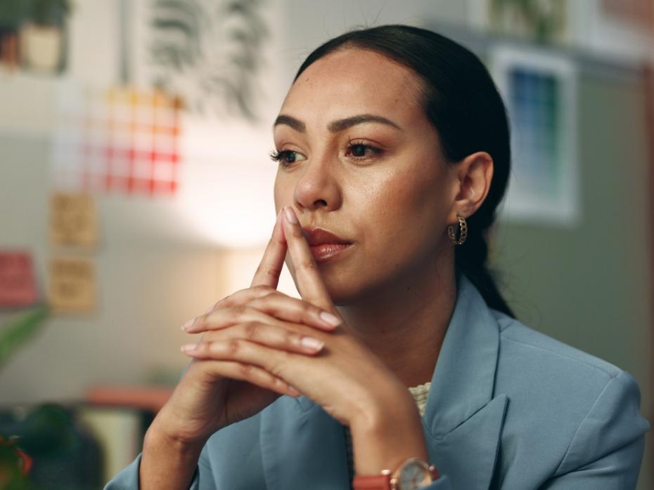 A woman deep in thought sitting at a desk 