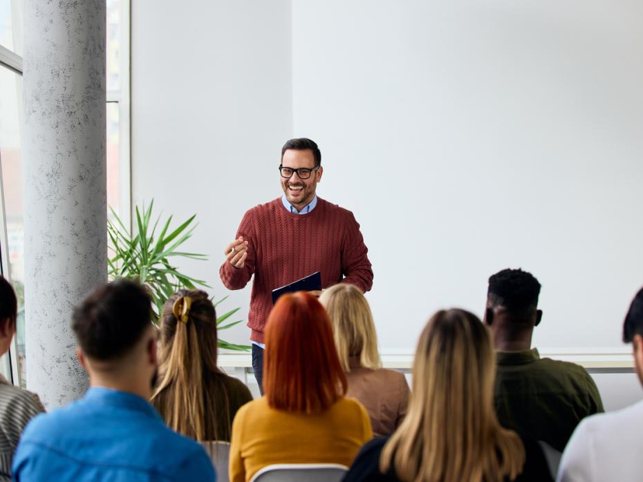 A lecturer giving an engaging presentation in front of a class full of students