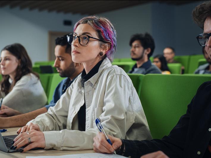 Woman with coloured hair in lecture hall