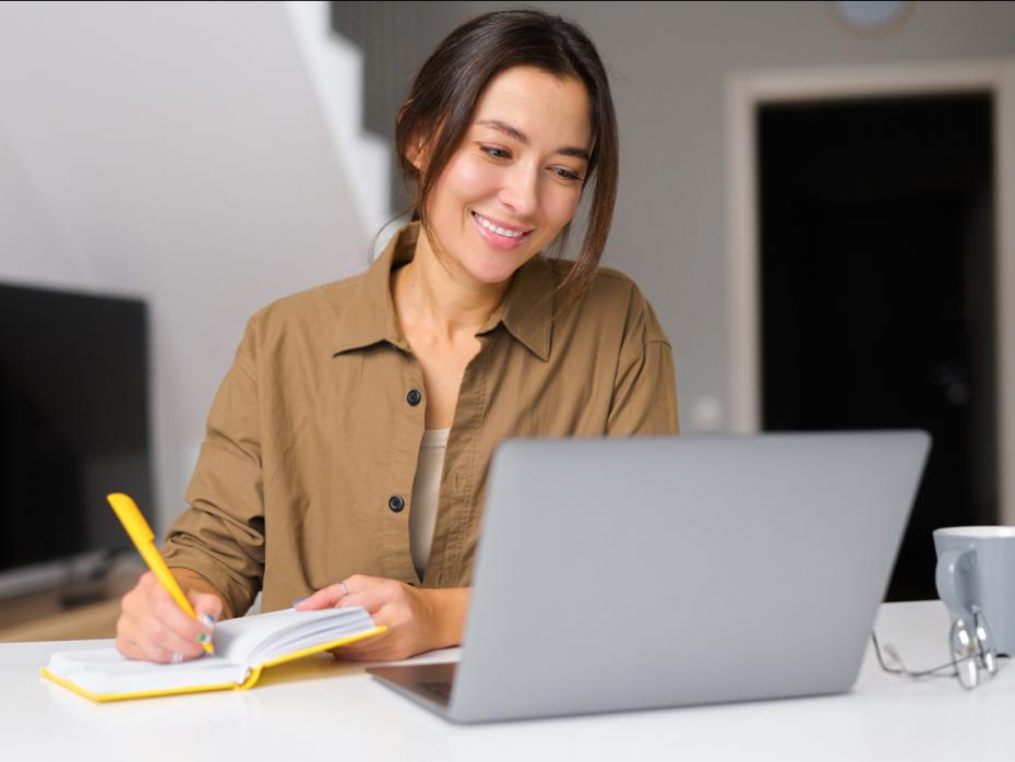 An academic writing a journal article on her laptop