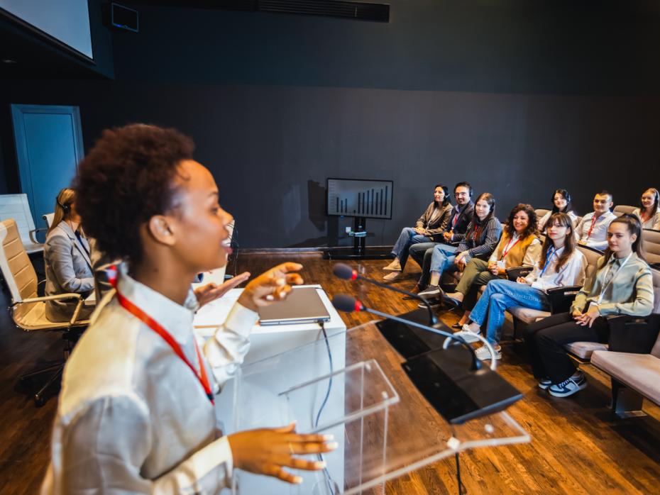 A lecturer at the front of class presenting to students 