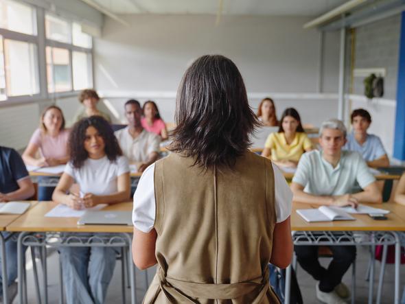 A university educator stands in front of a classroom