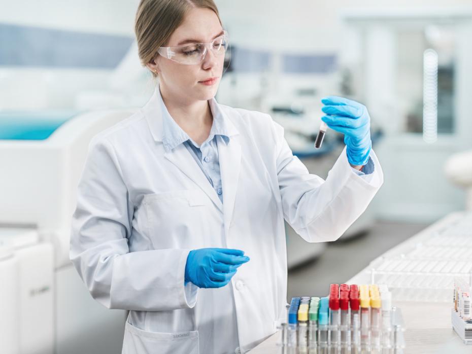 A woman in a lab coat testing samples in a lab