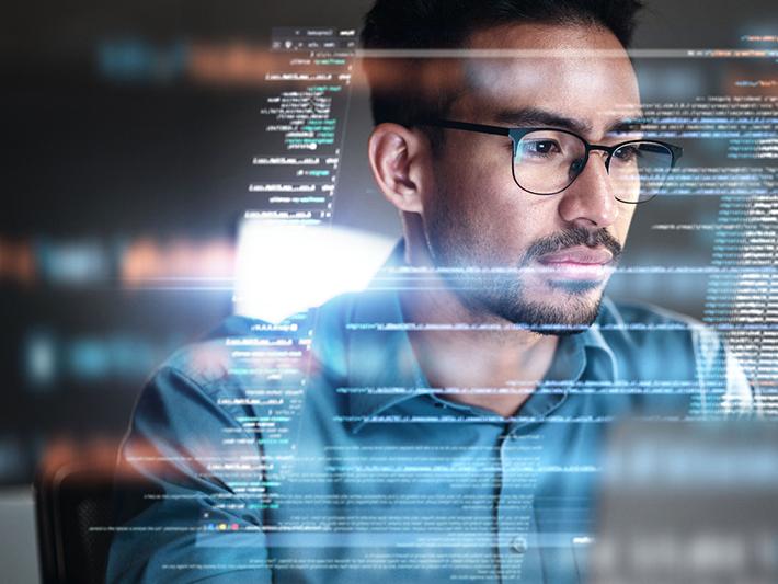 Asian man with glasses looking at screen
