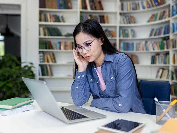 Young Asian woman concentrating working at laptop