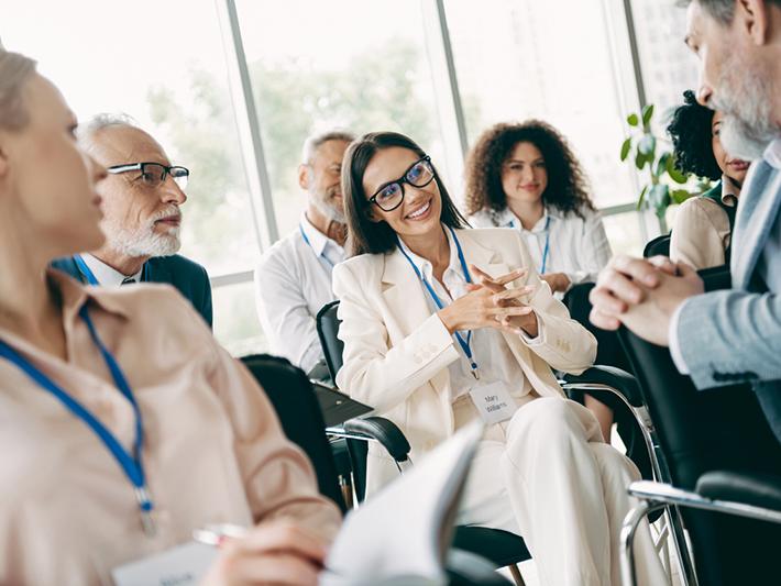 Group of professionals seated talking at a networking event