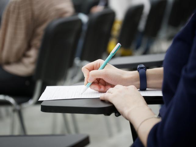 A student takes an exam at a desk