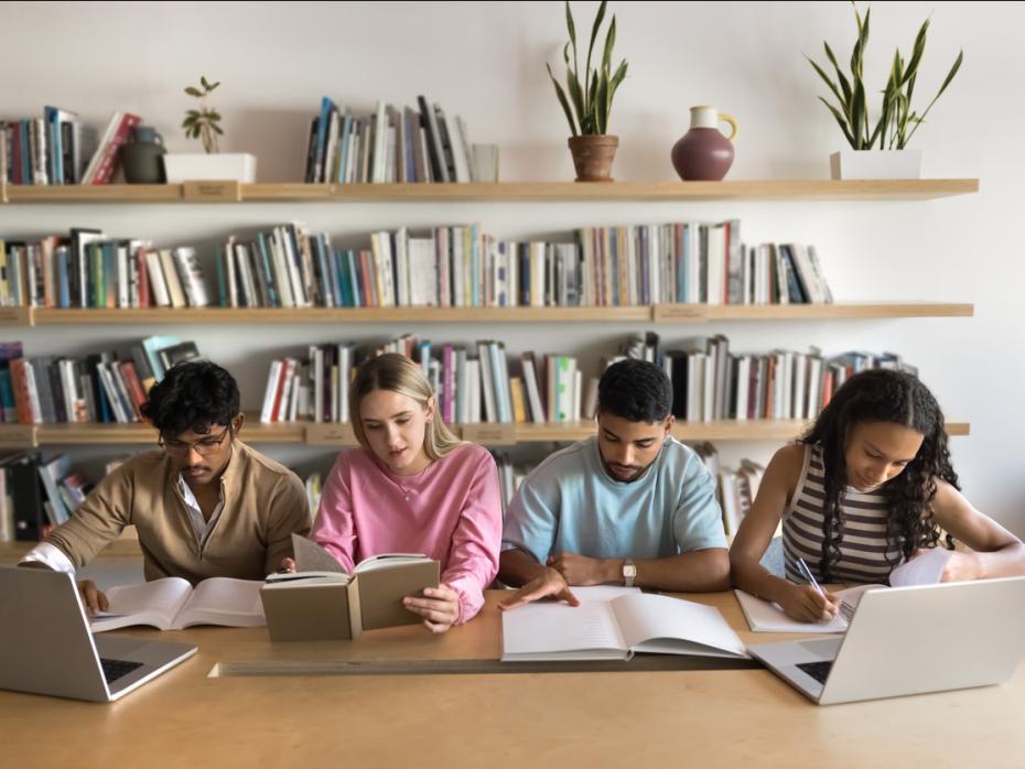 Students work with laptops and books