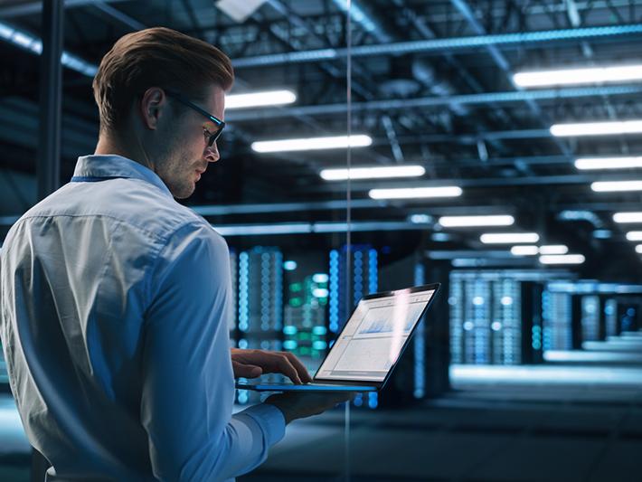 Man with laptop in a data centre