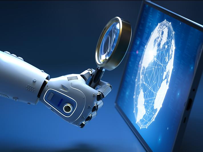 Robot hand holding magnifying glass up to computer screen