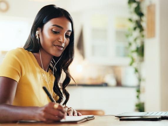 A student wearing earphones on her laptop