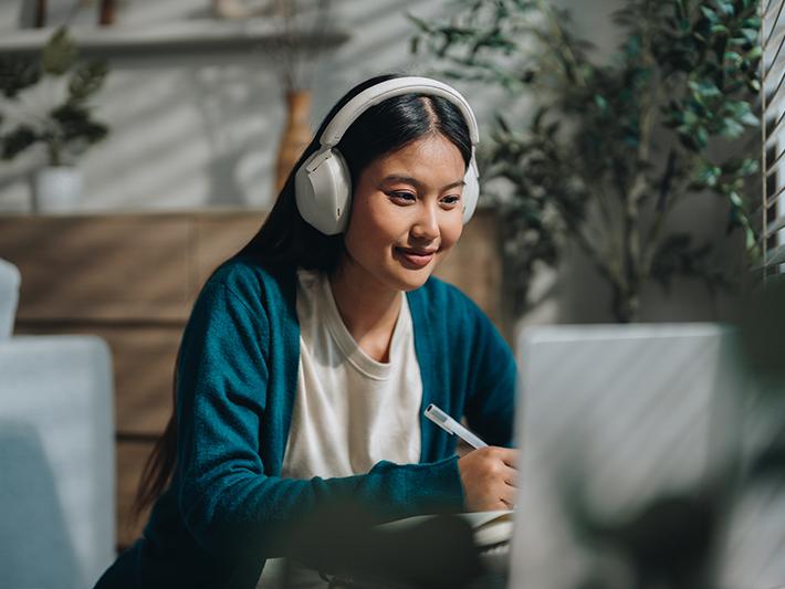 Young female Asian student doing an online course