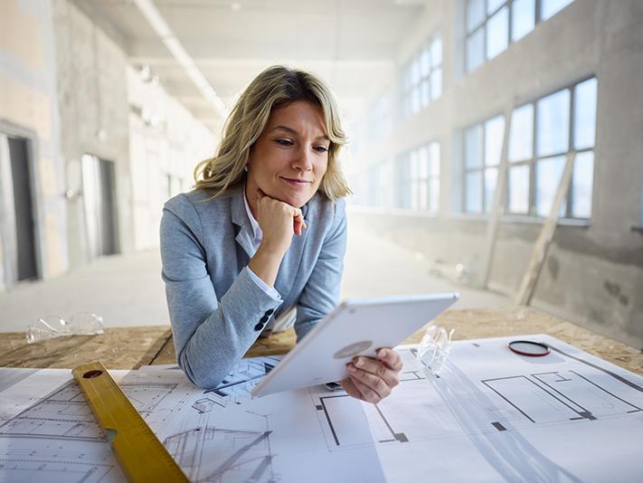 Female architect looking at plans on site
