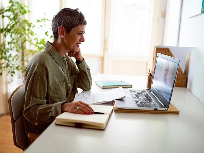 female mature-age online student working at laptop