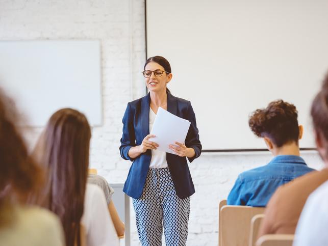 A teacher stands in front of class