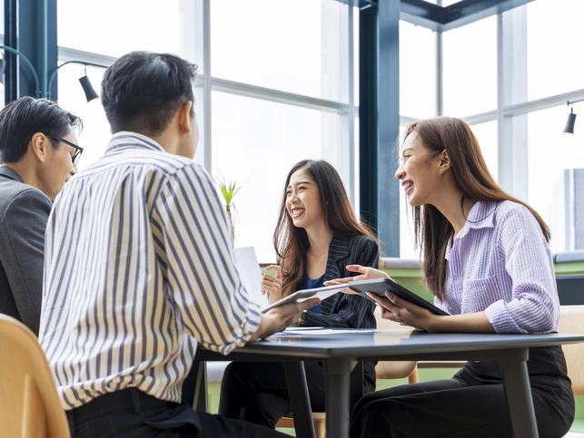 Students and mentors laugh around a table