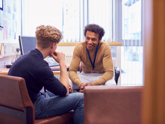 A counsellor offering advice to a student in an office