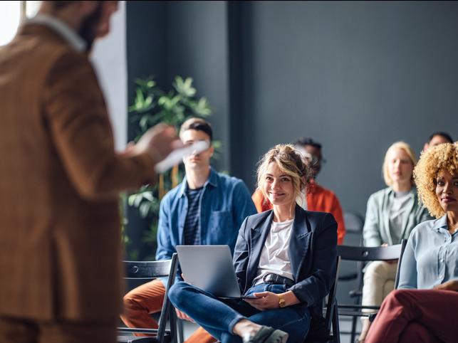 An academic laughs in a meeting