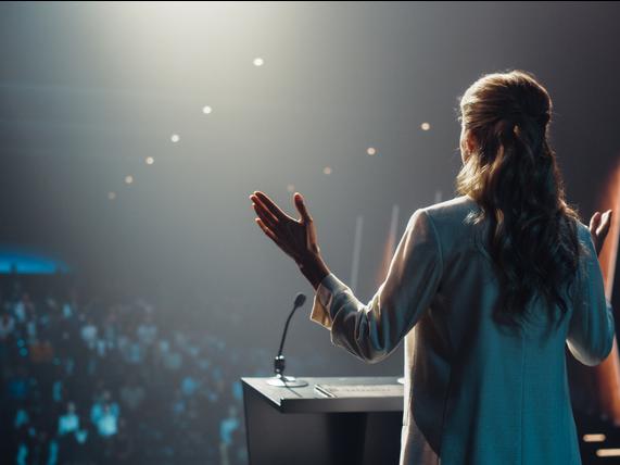 A woman on stage adressing an audience