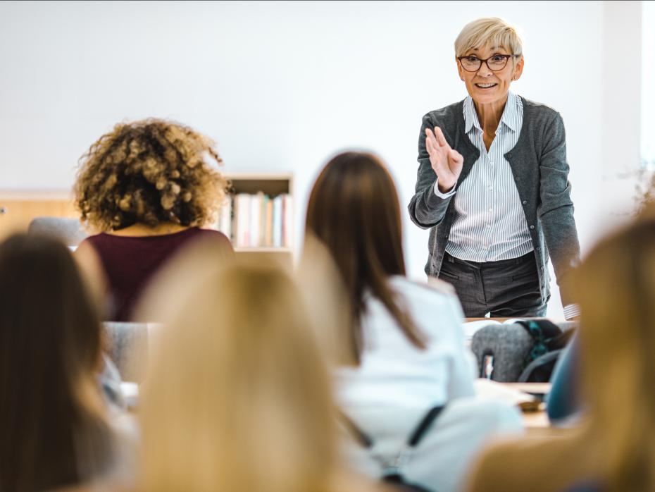 Mature female university teacher talking to a class