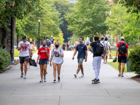 University students wearing covid masks as they walk around campus