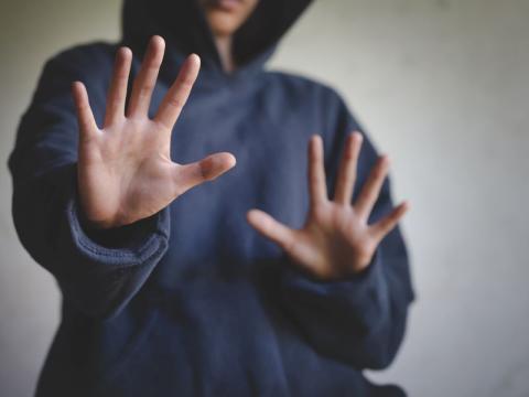 Woman holding up her hands against someone or something