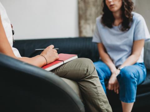 Two women sitting talk to one another